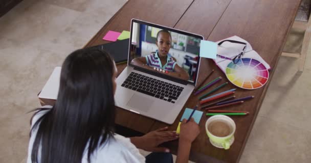 混合种族的女教师坐在桌旁 使用有在线学校课程的笔记本电脑 在隔离检疫期间隔离在家 — 图库视频影像