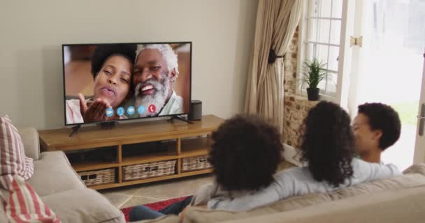 Африканская Американская Семья Сидит Диване Делает Видеозвонок Друзьями Экране Телевизора — стоковое видео