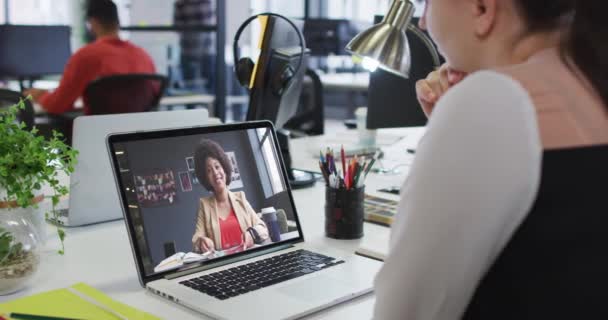 オフィスの女性同僚とノートパソコンでビデオ通話をしている白人女性 ビジネス プロ意識 テクノロジーの概念 — ストック動画