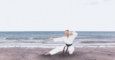 Sahilde fotokopi alanı olan siyah kuşaklı bir erkek dövüş sanatçısı kompozisyonu. spor ve yarışma konsepti dijital olarak oluşturulmuş görüntü.