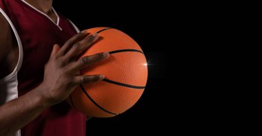 Siyah arka planda top ve fotokopi alanı olan erkek basketbolcunun orta bölümünün kompozisyonu. spor ve yarışma konsepti dijital olarak oluşturulmuş görüntü.