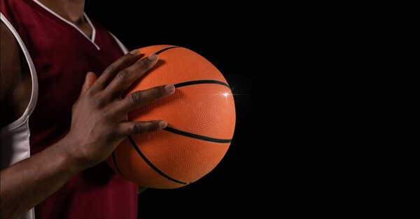 Composition of midsection of male basketball player with ball and copy space on black background. sport and competition concept digitally generated image.