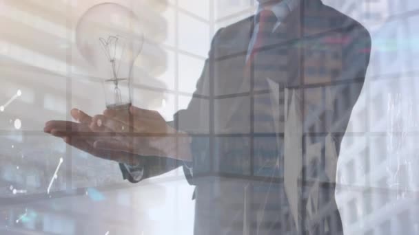 オフィスの背景にビジネスマンの手の上に電球のアニメーション 世界中のアイデアやネットワーキング ビジネスコンセプトをデジタルで — ストック動画