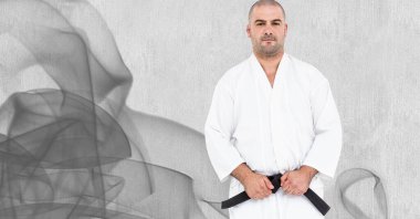 Beyaz erkek dövüşçü kompozisyonu siyah kuşak ile duman ve gri arka plan üzerinde. Spor ve rekabet konsepti dijital olarak oluşturulmuş imaj.