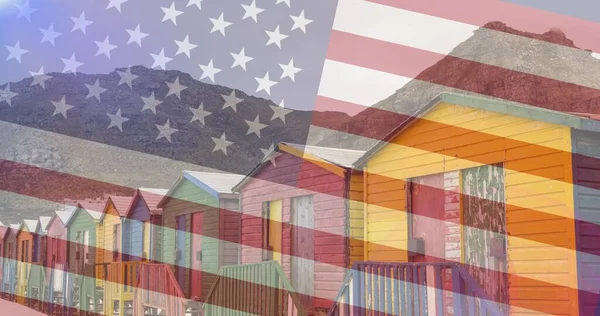 Composition of houses and mountains over american flag. patriotism and celebration concept digitally generated image.