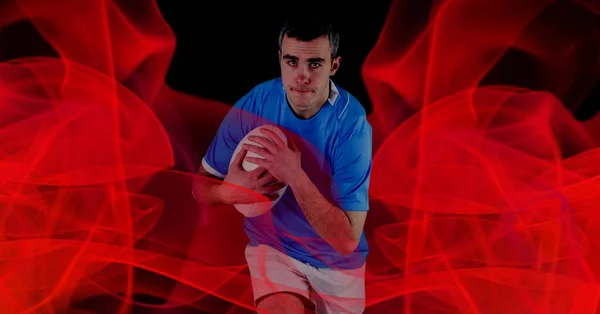Kafkasyalı Rugby Oyuncusunun Kırmızı Bulanıklı Siyah Arka Planda Topu Tutuşu — Stok fotoğraf