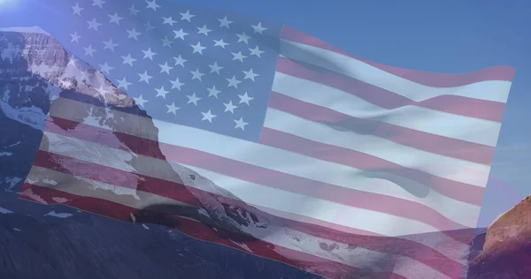 Composition of mountains and sky over american flag. patriotism and celebration concept digitally generated image.