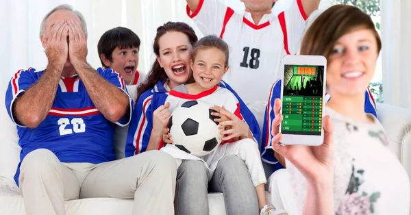 サッカーファンの家族の上にスポーツアプリとスマートフォンを使用して女性の構成 スポーツと競争の概念をデジタルで生成し — ストック写真