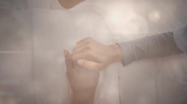 Yaşlı bir kadının elini tutan kadın hemşirenin üzerinde parlayan ışığın canlandırması. emeklilik ve yaşlı yaşam konsepti dijital olarak oluşturulmuş video.