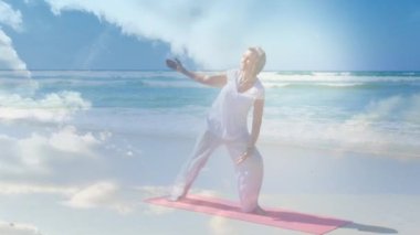 Kıdemli kadının deniz kenarında yoga yapması üzerine parlayan ışığın animasyonu. emeklilik ve mutlu yaşlı yaşam konsepti dijital olarak oluşturulmuş video.