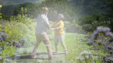 Bahçede dans eden mutlu yaşlı çiftin portresinin üzerinde parlayan ışığın animasyonu. emeklilik ve yaşlı yaşam konsepti dijital olarak oluşturulmuş video.