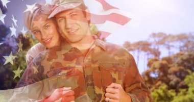 Amerikan bayrağı üzerinde gülümseyen karısını kucaklayan erkek askerin animasyonu. Asker, dijital olarak üretilen aile imajına geri dönüyor..