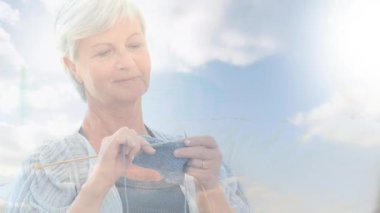 Mutlu yaşlı kadın örgü örerken parlayan ışığın animasyonu. emeklilik ve yaşlı yaşam konsepti dijital olarak oluşturulmuş video.