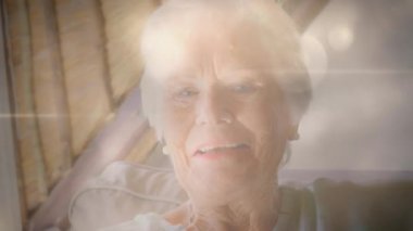 Mutlu yaşlı kadın portresinin üzerinde parlayan ışığın animasyonu. emeklilik ve yaşlı yaşam konsepti dijital olarak oluşturulmuş video.