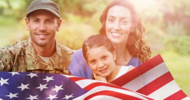 Amerikan bayrağı üzerinde gülümseyen eş ve kızı kucaklayan erkek askerin animasyonu. Asker, dijital olarak üretilen aile imajına geri dönüyor..