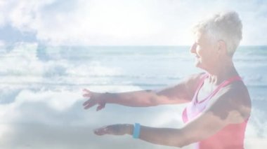 Deniz kenarında yoga yapan mutlu yaşlı kadının üzerinde parlayan ışığın animasyonu. emeklilik ve yaşlı yaşam konsepti dijital olarak oluşturulmuş video.