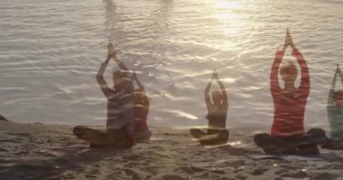 Deniz kenarında yoga yapan yaşlı kadınların üzerine parlayan ışığın animasyonu. emeklilik ve yaşlı yaşam konsepti dijital olarak oluşturulmuş video.