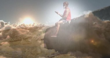 Yaşlı bir adamın kayanın üzerinde akıllı telefon kullanarak parlayan ışığın canlandırması. emeklilik ve sağlıklı yaşlı yaşam konsepti dijital olarak oluşturulmuş video.