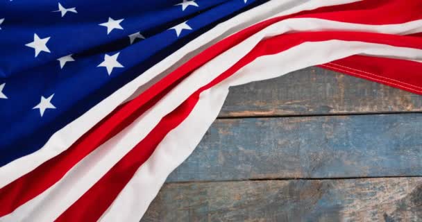 木製のテーブルの上に横たわるアメリカ国旗のアニメーション 愛国心とお祝いのコンセプトをデジタルで — ストック動画