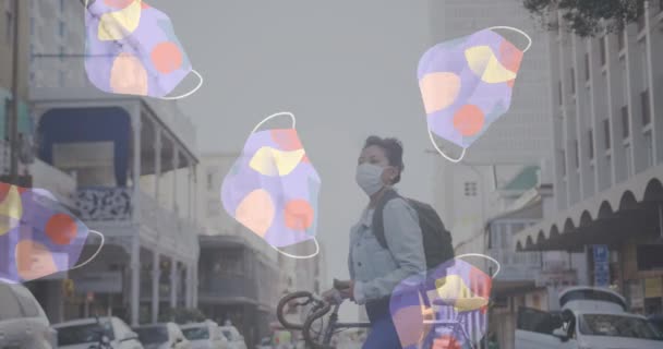 自転車で通りを横断する女性の顔のマスクに対して移動する複数の顔のマスク コロナウイルスCovid 19パンデミックの概念 — ストック動画
