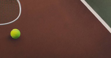 Tenis topu ve raketin kompozisyonu. Tenis kortunda fotokopi alanı var. Spor ve rekabet konsepti dijital olarak oluşturulmuş imaj.