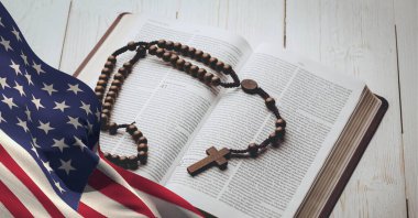 Ahşap arka planda İncil 'in üzerinde Amerikan bayrağı sallamak. Amerikan vatanseverliği ve din arka plan tasarımı kavramı