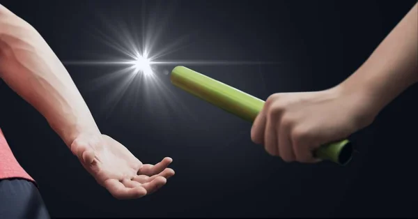 Corte Médio Mão Passando Bastão Contra Ponto Luz Fundo Cinza — Fotografia de Stock