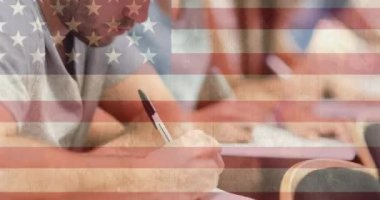 Sınıfta yazan gülümseyen öğrencilerin üzerine Amerikan bayrağı animasyonu. okul, eğitim ve öğrenim konsepti dijital olarak oluşturulmuş video.