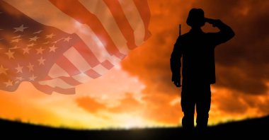 Gün batımında gökyüzünde dalgalanan Amerikan bayrağıyla selamlayan askerin silueti. Vatanseverlik, bağımsızlık ve kutlama konsepti dijital olarak oluşturulmuş imaj.