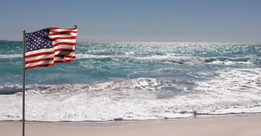 Mavi gökyüzüne ve deniz kenarına Amerikan bayrağı sallamanın kompozisyonu. Birleşik Devletler vatanseverliği ve bağımsızlık kavramı dijital olarak oluşturuldu.