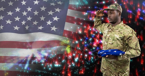 Composition of male soldier saluting over american flag and fireworks. american patriotism, independence and celebration concept digitally generated image.