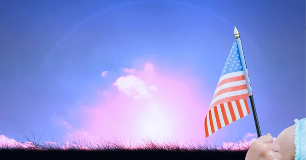 雲と青空の上にアメリカ国旗を掲揚する白人の手の構成 アメリカの愛国心独立とお祝いの概念をデジタルで生成されたイメージ — ストック写真