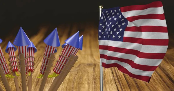 Composition of american flag with fireworks over wooden table. american patriotism, independence and celebration concept digitally generated image.