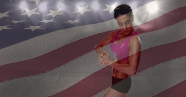 Mává Americkou Vlajkou Nad Atletkou Ohýbá Biceps Proti Sportovnímu Stadionu — Stock video