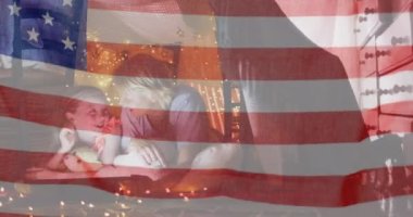 Amerikan bayrağı, evinde battaniye altında beyaz anne ve kızına karşı dalgalanıyor. Amerikan bağımsızlığı ve kutlama konsepti