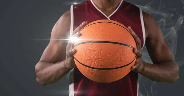 Sección Media Del Jugador Baloncesto Masculino Sosteniendo Pelota Contra Humo —  Fotos de Stock