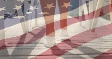 Amerikan bayrağı, beyaz kadının ahşap iskelede yürüyen alt kesimine karşı sallanıyor. Amerikan bağımsızlığı ve kutlama konsepti