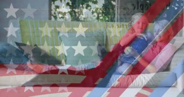 Anne ve oğlunun köpekle oynaması üzerine Amerikan bayrağının hareketli çizgileri ve yıldızların animasyonu. Vatanseverlik, bağımsızlık ve kutlama konsepti dijital olarak oluşturulmuş video.
