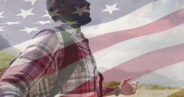 Sahilde kollarını açan bir adamın üzerinde hareket eden Amerikan bayrağı animasyonu. Vatanseverlik ve kutlama konsepti dijital olarak oluşturulmuş video.