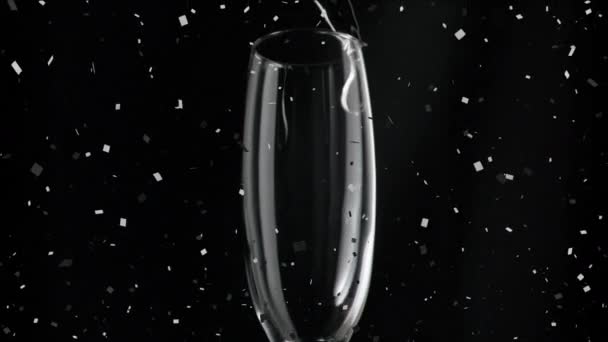 香槟酒倒入玻璃杯 五彩纸屑落在黑色背景上 庆祝和聚会的概念 数码制作的视频 — 图库视频影像