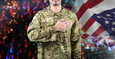 Amerikan bayrağı ve havai fişekleri üzerinde eli yüreğinde bir erkek askerin kompozisyonu. Vatanseverlik, bağımsızlık ve kutlama konsepti dijital olarak oluşturulmuş imaj.