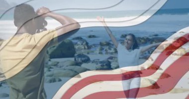 Sahilde fotoğraf çeken Afro-Amerikan çifti üzerine Amerikan bayrağı animasyonu. Vatanseverlik ve kutlama konsepti dijital olarak oluşturulmuş imaj.