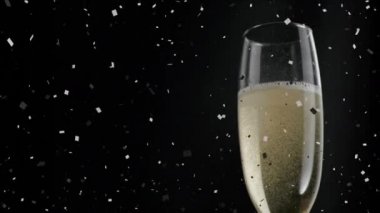 Siyah arka planda konfetilerin düştüğü bir kadeh şampanya animasyonu. kutlama ve parti konsepti, dijital olarak oluşturulmuş video.