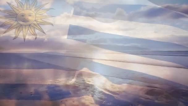 日当たりの良い海辺に手を振ってウルグアイの旗のアニメーション 愛国心夏休みのコンセプトをデジタルで生成し — ストック動画