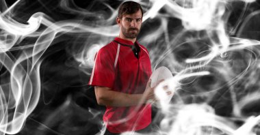 Siyah arka planda rugby topu tutan erkek rugby oyuncusunun kompozisyonu. spor ve yarışma konsepti dijital olarak oluşturulmuş görüntü.