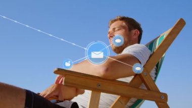 Sahildeki iskemlede oturan adamın üzerindeki simgelerle bağlantı ağının animasyonu. küresel bağlantılar ve sosyal medya konsepti dijital olarak oluşturulmuş video.