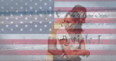 Amerikan bayrağının animasyonu ve birbirini kucaklayan çift üzerinde hareket eden metin. Vatanseverlik ve kutlama konsepti dijital olarak oluşturulmuş video.