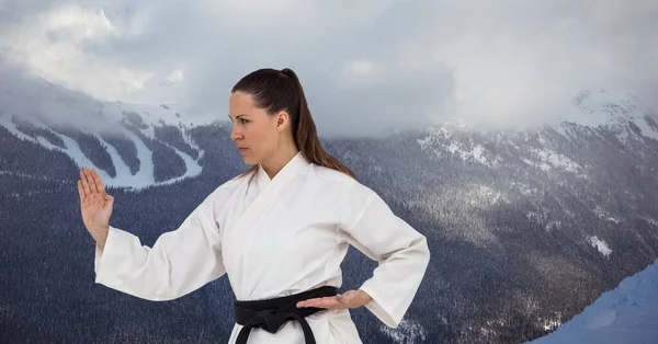 冬の風景に対する黒帯と白人女性の武道家のデジタル複合画像 スポーツ競技とトーナメントのコンセプト — ストック写真