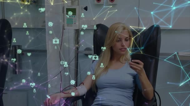 病院でスマートフォンを使用して白人女性に対して回転する医療アイコンの球 世界的なネットワーキングと医療研究技術の概念 — ストック動画