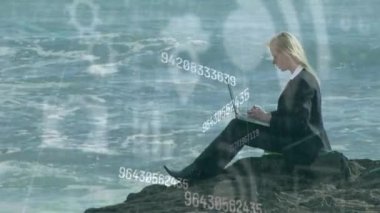 Bilgisayar kullanan iş adamları üzerinde sayıların ve dijital simgelerin animasyonu. küresel iletişim, teknoloji ve dijital arayüz kavramı dijital olarak oluşturulmuş video.